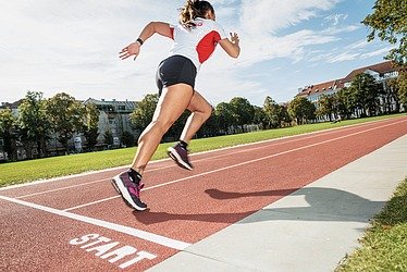Foto von einer Läuferin auf Laufbahn
