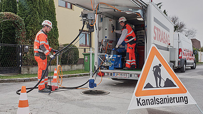 Foto von zwei Männer die eine Kanalsanierung vorbereiten