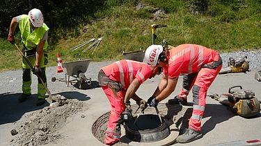 Foto von Männern die am Schachtrahmen arbeiten