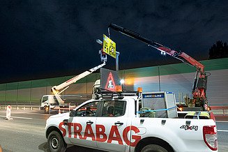 Foto vom Anbringen eines Überkopfwegweisers