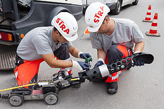 Foto von zwei Männer, welche eine Kanalinspektion mittels 3D Scanverfahren durchführen