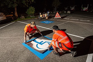 Foto von Bauarbeitern die eine Parkplatzmarkierung anbringen